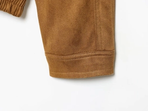 Detailed close-up of brown suede jacket cuff with corduroy texture and double stitching