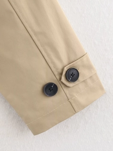 Detailed close-up of khaki trench coat cuff featuring adjustable double button tabs