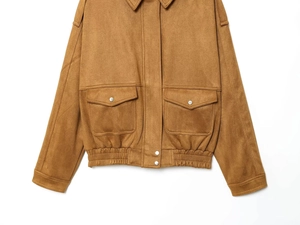 Detail view of brown suede jacket showing flap pockets with metallic silver snap buttons