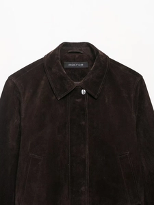Close-up detail of dark brown suede jacket collar with silver metal button and texture