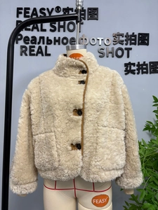 Detail der locker sitzenden Sherpa-Jacke mit Stehkragen und braunem Kunstlederbesatz