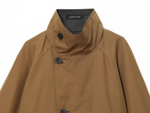 Detailed close-up of khaki trench coat collar with stripe lining and INDEFEIR brand label