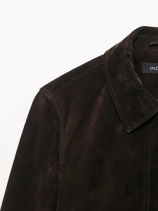 Detailed close-up of dark brown suede jacket lapel with premium stitching and texture