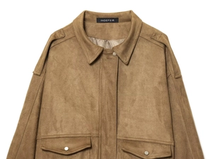 Detail of suede bomber jacket featuring flap pockets with silver buttons and classic collar
