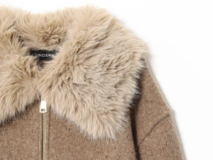 Detail of fluffy faux fur collar and premium gold metal zipper on brown knit jacket