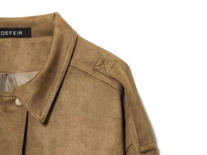 Detail of suede bomber jacket collar showing metallic snap buttons and shoulder epaulettes