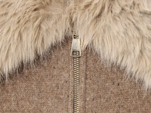 Detailed macro view of brown knit jacket collar with soft faux fur trim and gold zipper