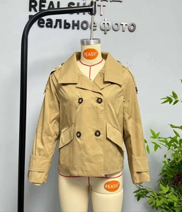Detailed close-up of a khaki double-breasted short trench jacket with wide lapels