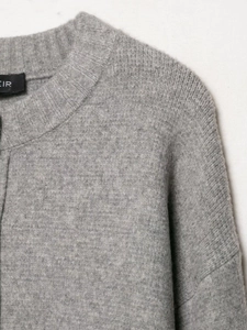 Close-up of the grey knit sweater featuring a ribbed round neckline and soft texture