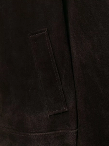 Detailed close-up of vertical welt pocket on dark brown suede texture jacket
