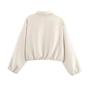 Rear view of minimalist cream cropped jacket featuring drop shoulder and elastic hem detail