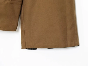 Detail view of brown twill cotton jacket cuff with durable double stitching and striped lining