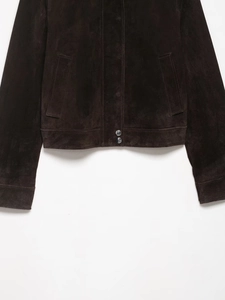 Detail of dark brown suede jacket featuring silver metal snap buttons and velvet texture