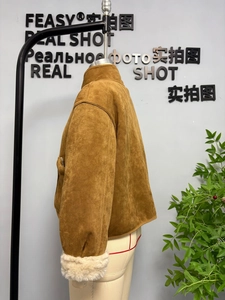 Detail einer braunen Wildlederjacke mit weißen Plüschmanschetten und Stehkragen