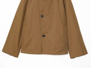 Detail of tan reversible coat with double button closure and stylish plaid lining