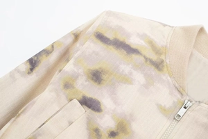 Détail du blouson aviateur avec motif tie-dye beige, fermeture éclair et col côtelé