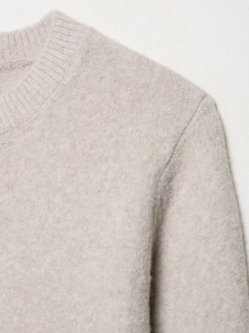 Close-up of ribbed crewneck and soft knit texture on beige oatmeal knit cardigan