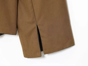 Detail of dark khaki windbreaker cuff with split design and striped lining