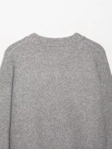 Detailed close-up of gray knit sweater showing high-quality round neck and shoulder texture