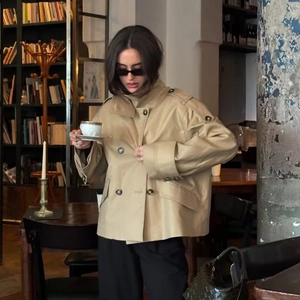 Short khaki double-breasted trench coat with shoulder straps and oversized buttons