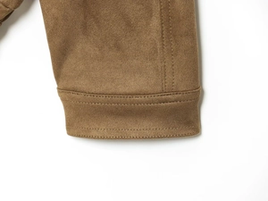 Detailed close-up showing the double-stitched hem on a tan faux suede bomber jacket