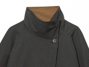 Detail of grey houndstooth check coat featuring a high neck collar and two matte buttons