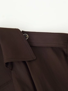 Close-up of deep brown midi dress showing refined collar, button, and premium stitching