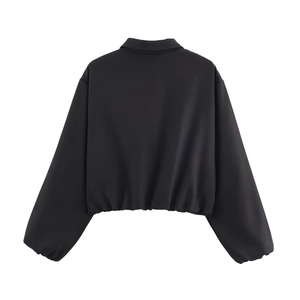 Rear view of black cropped puffer jacket with elastic hem and elastic cuffs