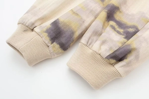 Détail du poignet élastique côtelé d'une veste aviateur avec imprimé tie-dye artistique