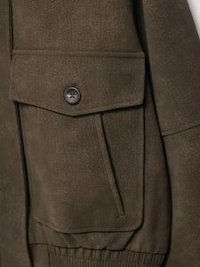 Detail of olive green suede jacket featuring cargo flap pocket and elastic ribbed hem