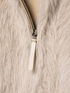 Detail of the high-quality gold zipper with leather pull on a beige faux fur jacket