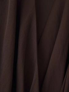 Close-up of chocolate brown twill fabric showing fine texture and subtle sheen of the dress