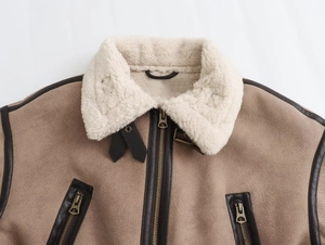 Dettaglio giacca bomber in camoscio marrone con fodera in montone bianco e zip metalliche