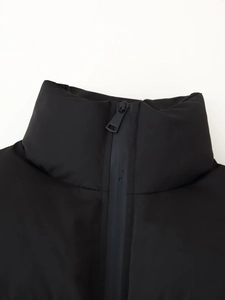 Close-up of black puffer jacket stand collar with matte fabric and metal zipper detail
