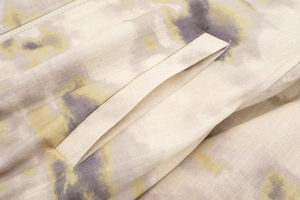 Détail du tissu ripstop à imprimé tie-dye avec poche en biais et zip métallique sur la veste