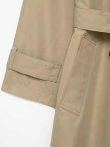 Close-up of the adjustable cuff strap and precision stitching on khaki trench coat