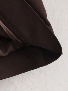 Detail of dark brown short trench coat showing twill texture and smooth inner lining