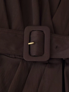Detail of dark brown midi dress featuring twill fabric texture and golden buckle belt