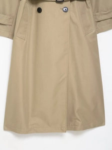 Detailed close-up of khaki trench coat featuring classic double-breasted buttons and belt