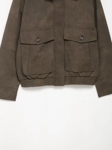 Close-up of deep brown faux suede jacket featuring large utility pockets and elastic hem