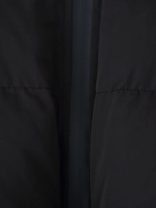 Close-up of matte black fabric with horizontal quilting on this padded winter jacket