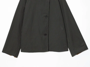 Macro shot of dark grey plaid pattern fabric with classic black button closure detail