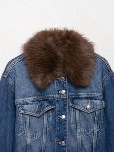 Detailed view of blue denim jacket featuring a plush faux fur collar and metal buttons