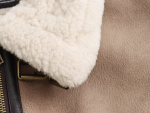 Dettaglio del collo in shearling sintetico e camoscio marrone con fibbia in bronzo