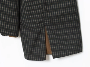 Detailed macro view of checkered wool blend fabric with refined back vent and inner lining