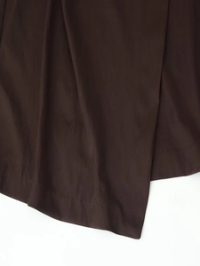 Detail of dark brown twill fabric texture on a long sleeve belted midi dress