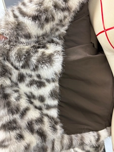 Close-up of leopard print faux fur jacket with soft texture and smooth dark brown lining