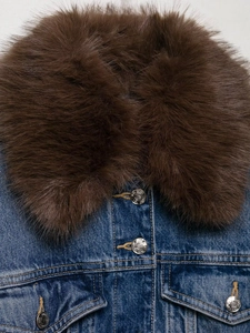 Detailed macro view of the blue denim jacket featuring a thick brown faux fur collar