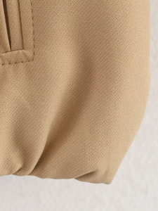 Close-up of khaki puffy jacket fabric showing high-quality stitching and twill texture