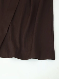 Detailed macro view of dark brown midi dress fabric with textured twill weave and neat stitching